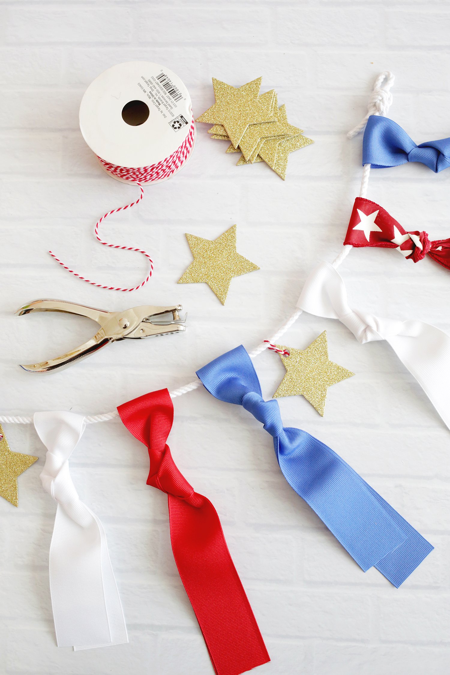 ribbons, string, paper stars and a hole punch to make a ribbon garland. 