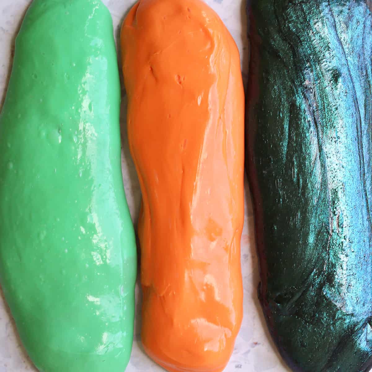 Green, orange and galaxy slime stretched out. 