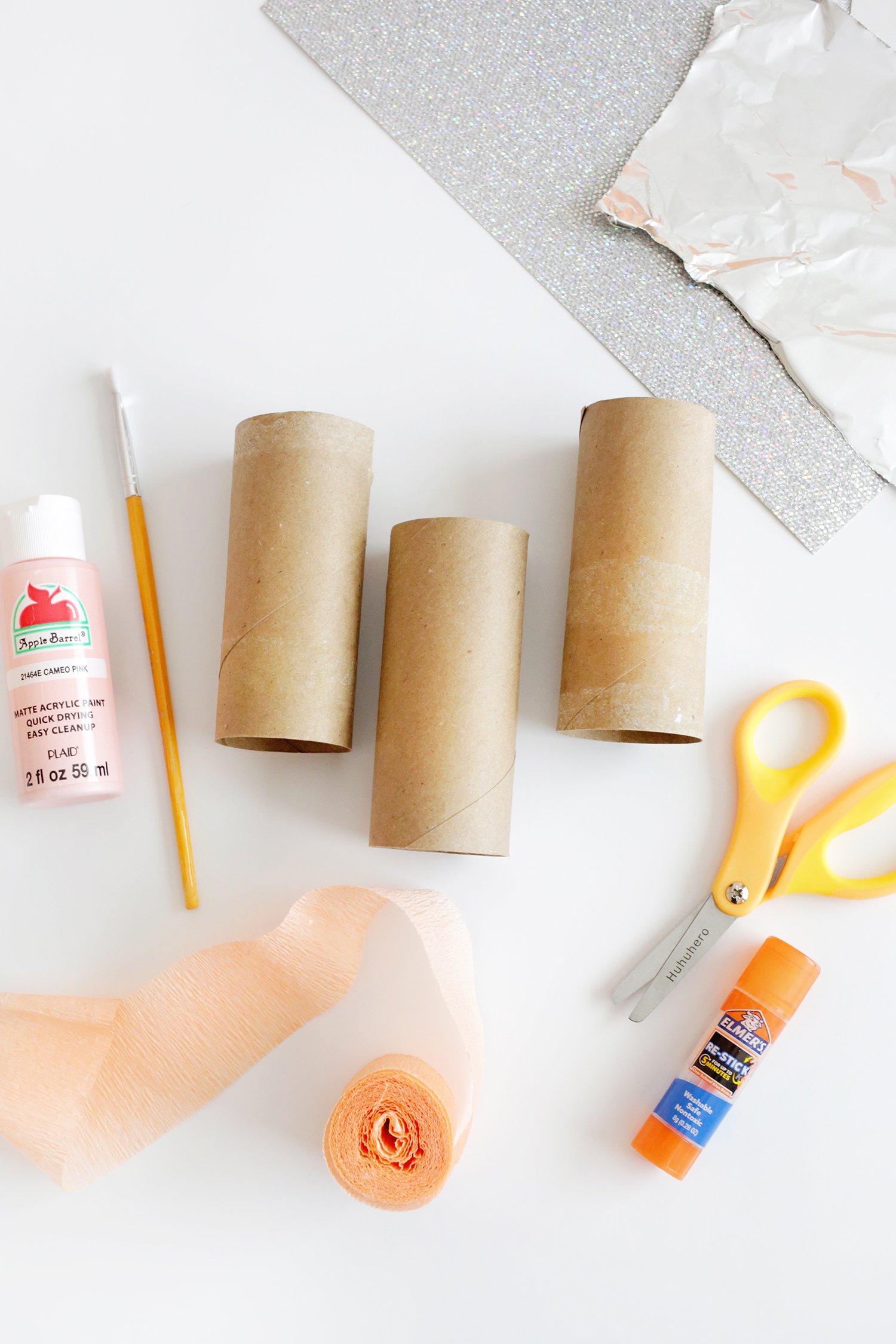 cardboard toilet paper tubes, paint and brush, crepe paper, scissors, and glue