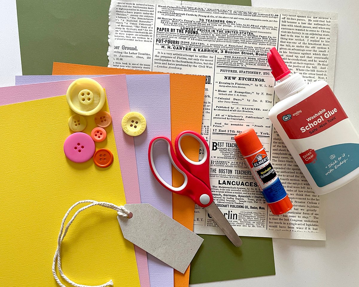 cardstock, buttons, school glue, gluestick and scissors ready to make a paper craft. 