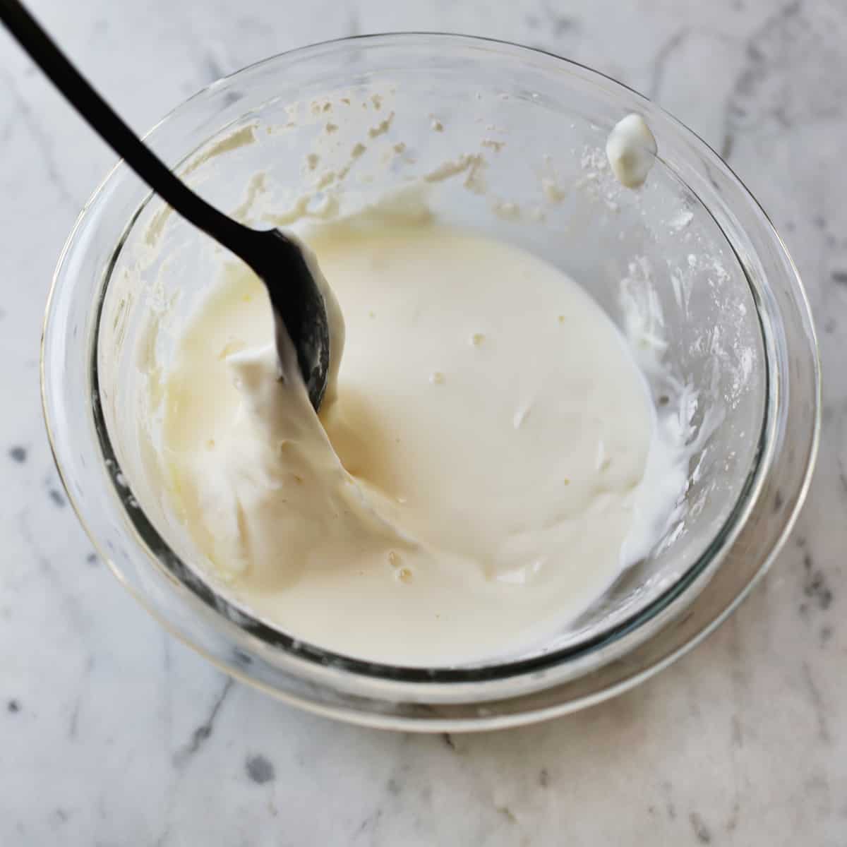 A spoon stirring together cornstarch and water. 