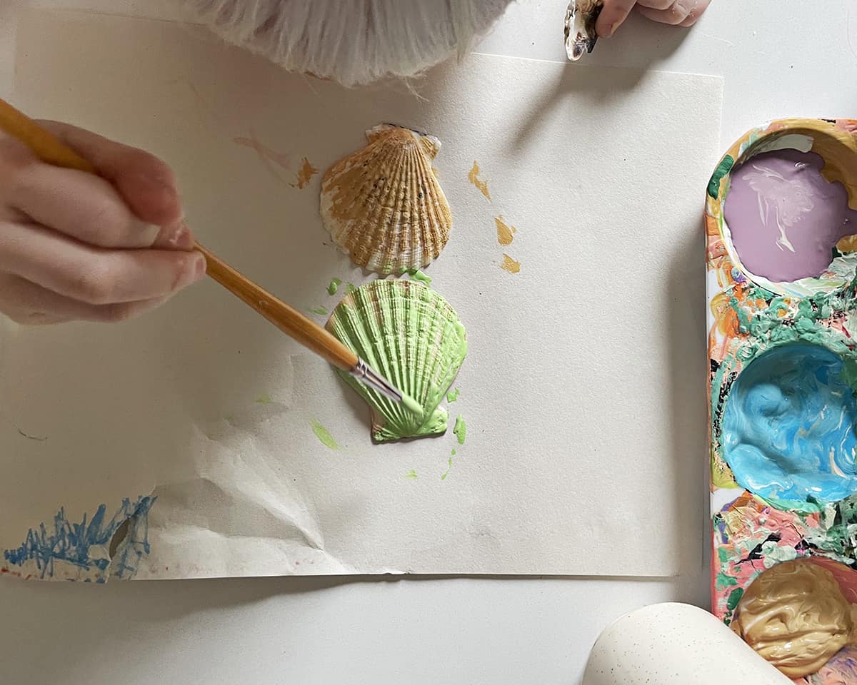 Seashell being painted green. 