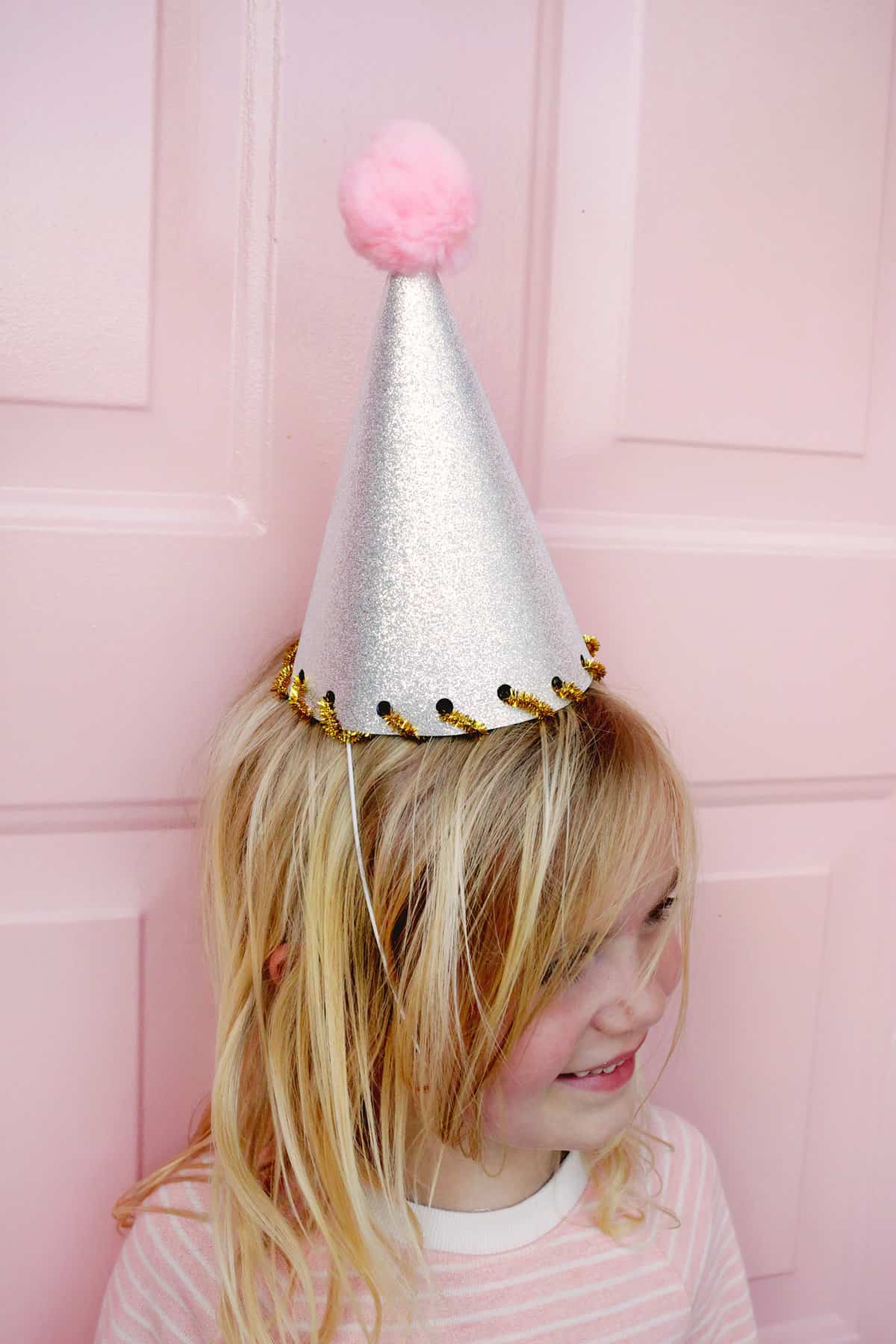 girl wearing a silver sparkle party hat