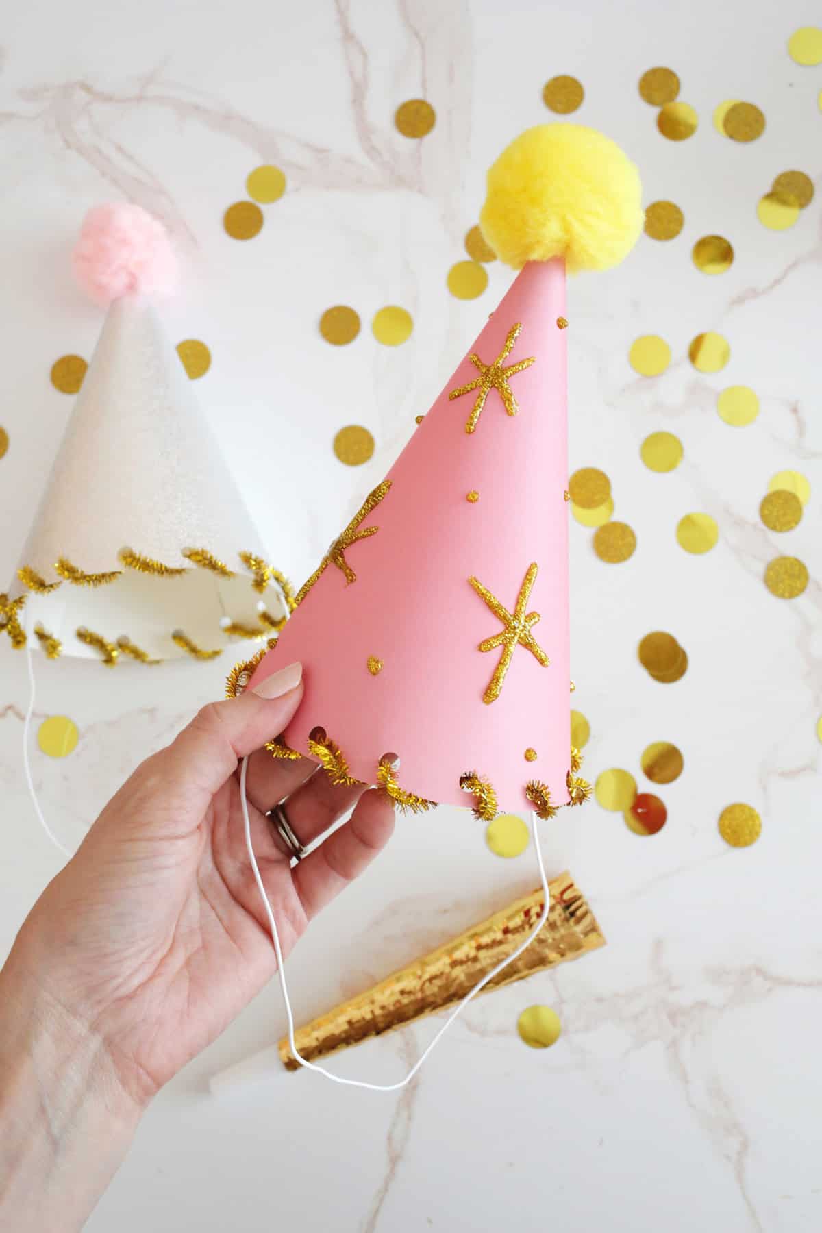 pink party hat decorated with gold stars