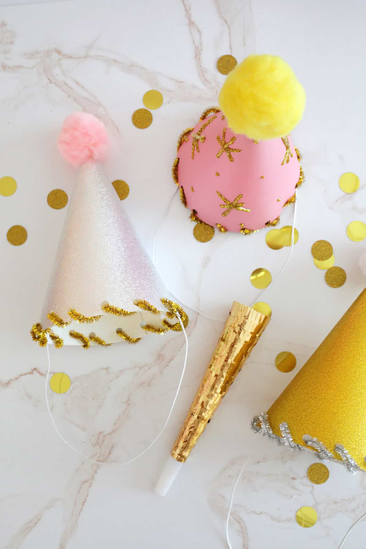 glitter paper party hats with pom poms on top