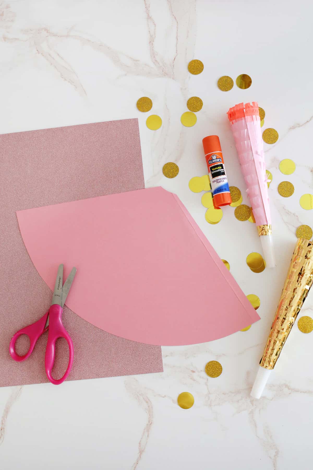 supplies of paper, glue, and scissors to make party hat