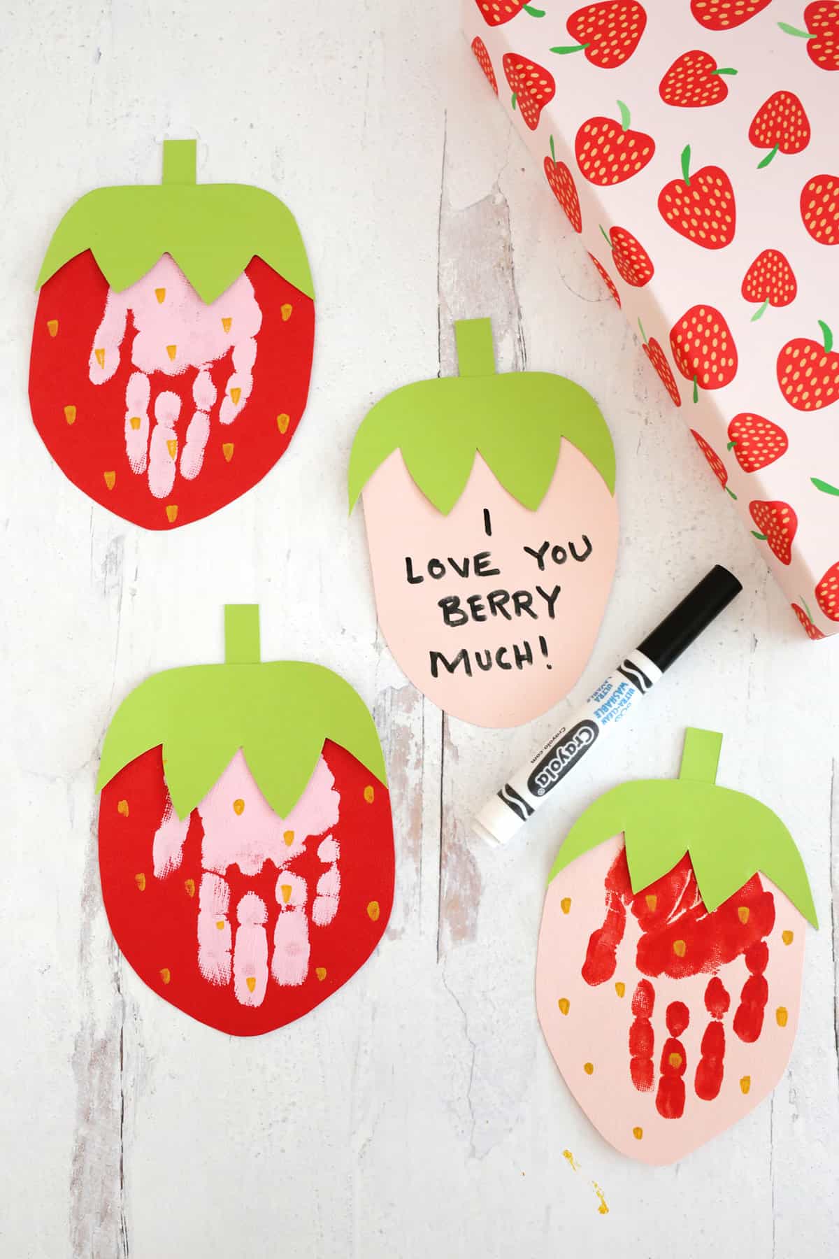 strawberry handprint cards sitting on table