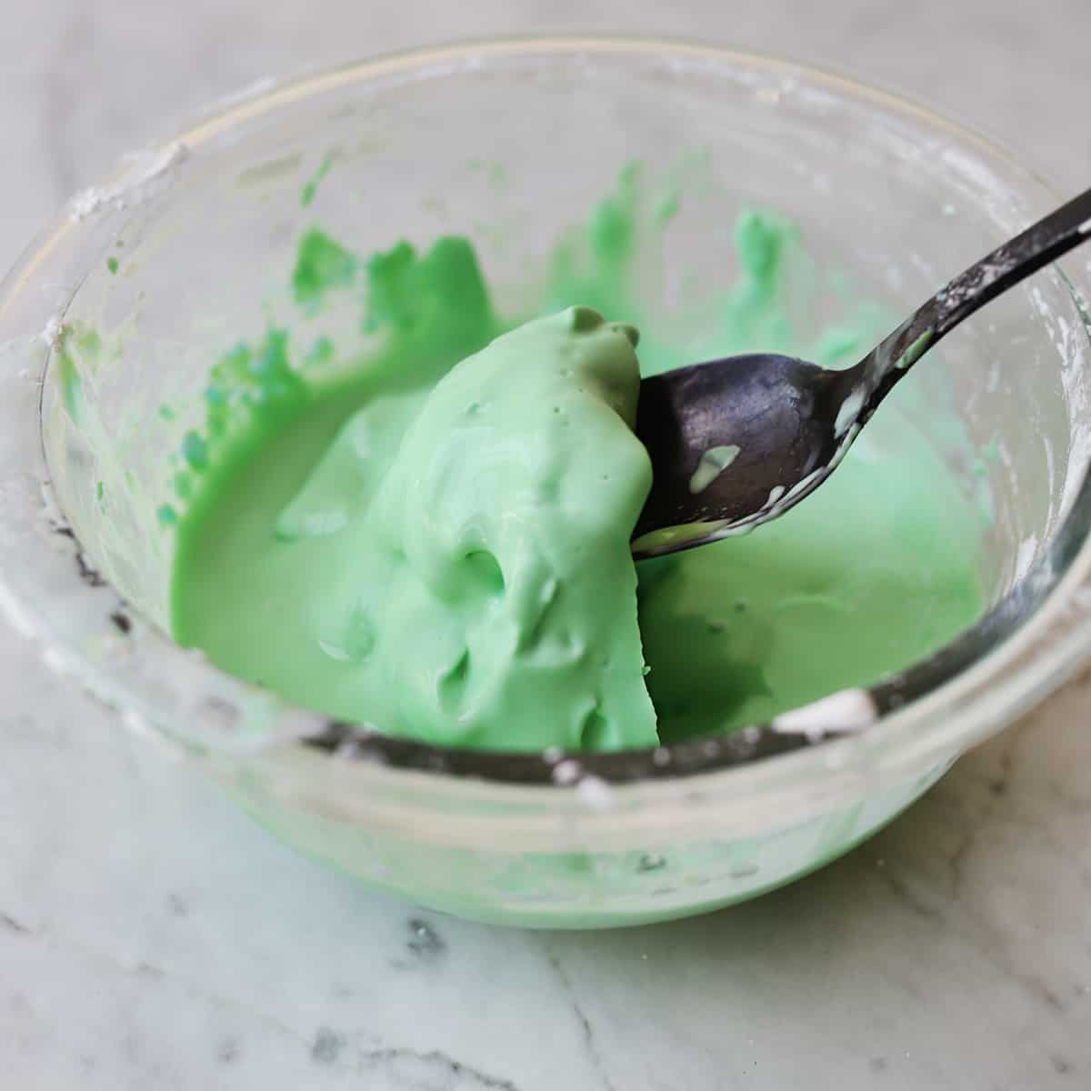 spoon scooping out oobleck from bowl.