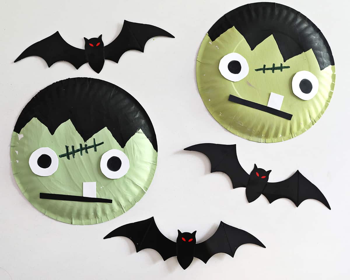paper plates painted to look like frankenstein next to paper bats. 