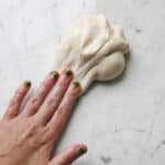 hand smearing edible white slime