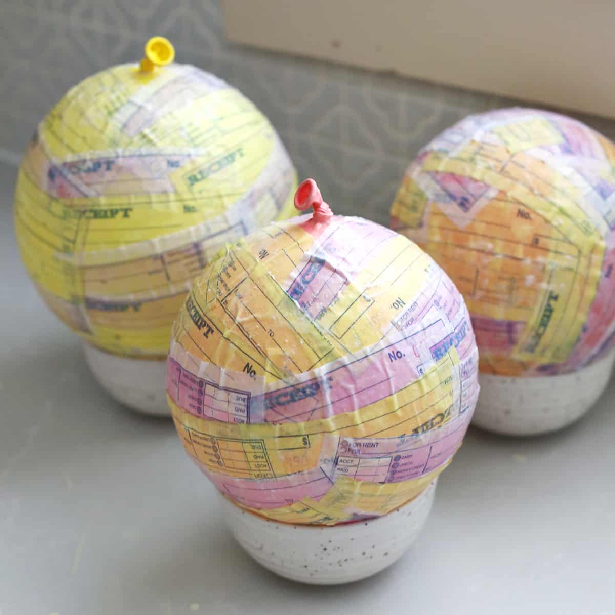 Balloons drying in bowls after being covered with paper pieces and paper-mache paste. 