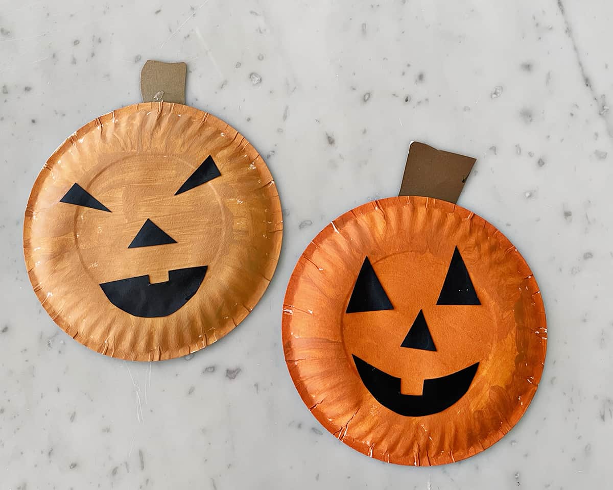 Paper plates painted orange with faces added to make jack-o-lanterns.