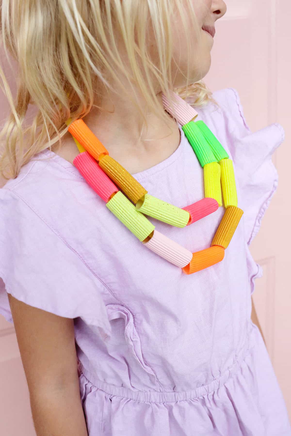 pasta necklace made with multiple colors being worn by a child. 
