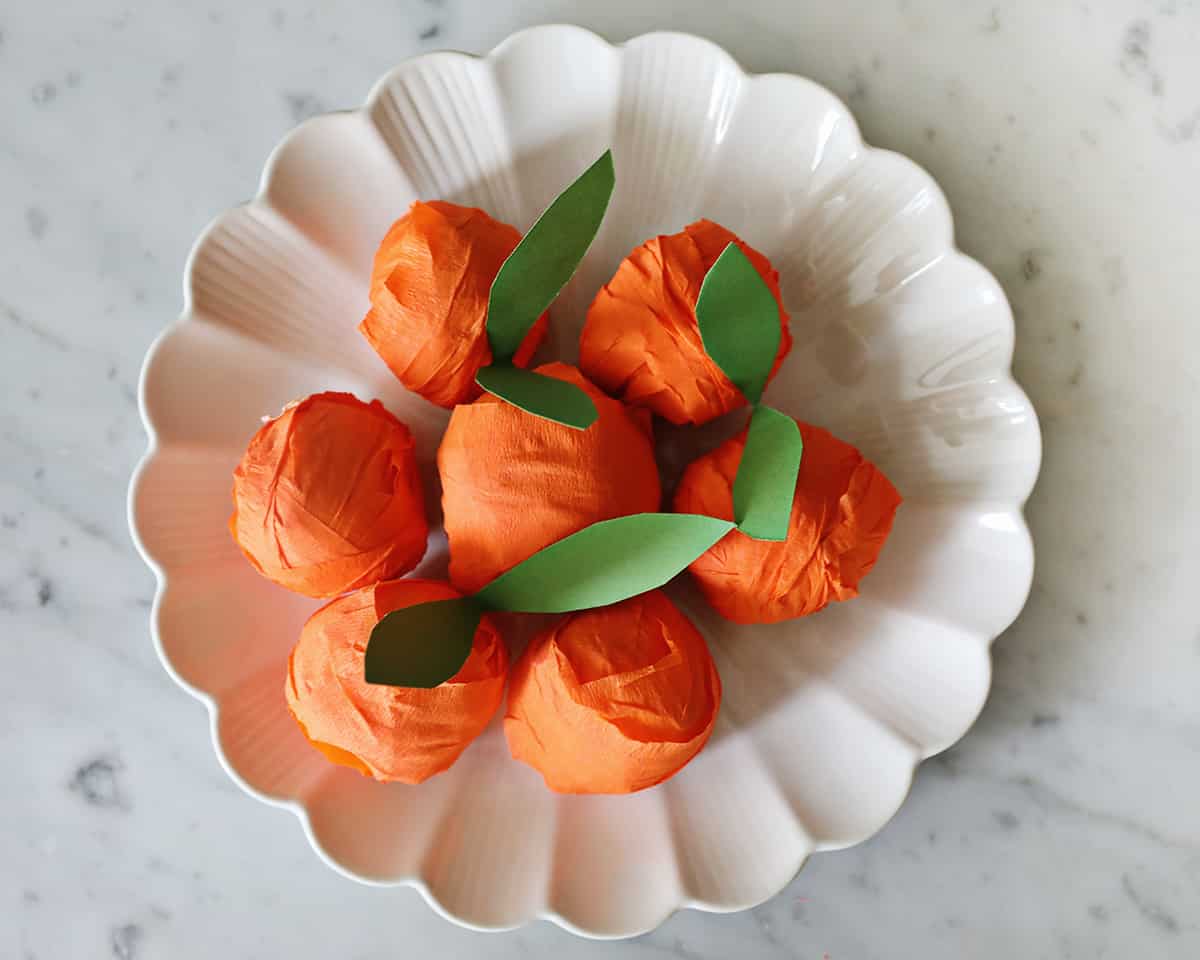 bowl of surprise balls made from crepe paper to look like oranges.