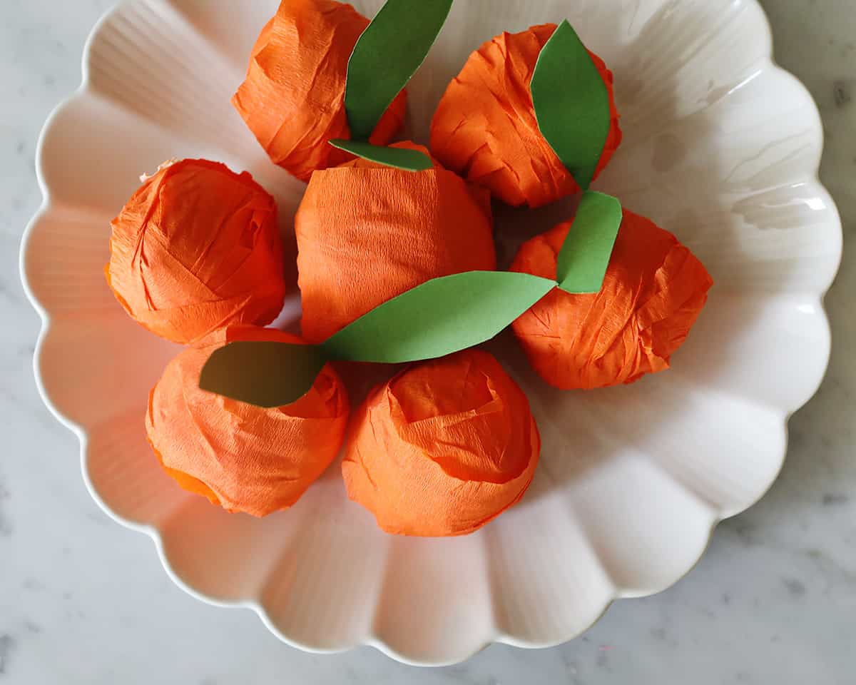 bowl of surprise balls made from crepe paper to look like oranges.