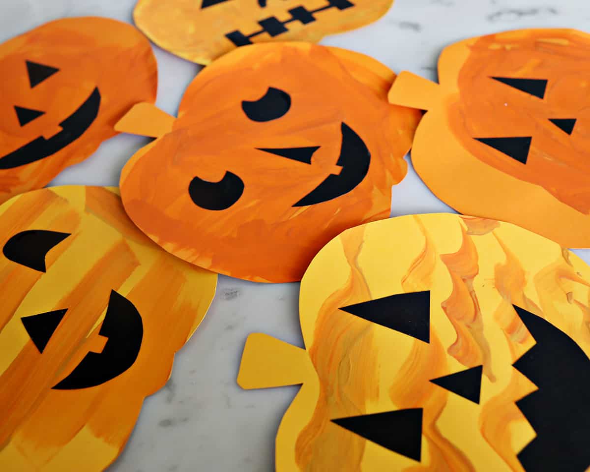 Paper cut out pumpkins decorated for Halloween.