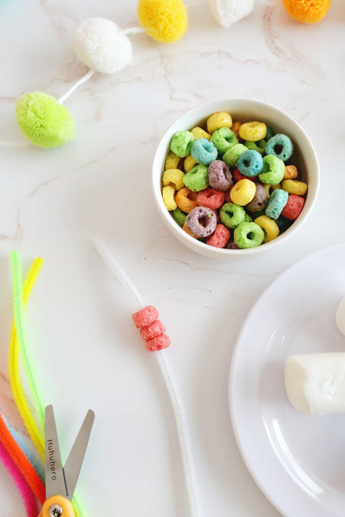 threading fruit loops onto a pipe cleaner