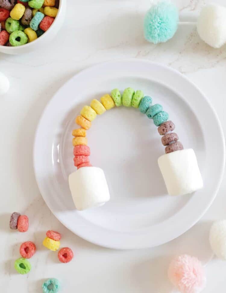 fruit loops made into an arch with marshmallows on the ends to make a rainbow.