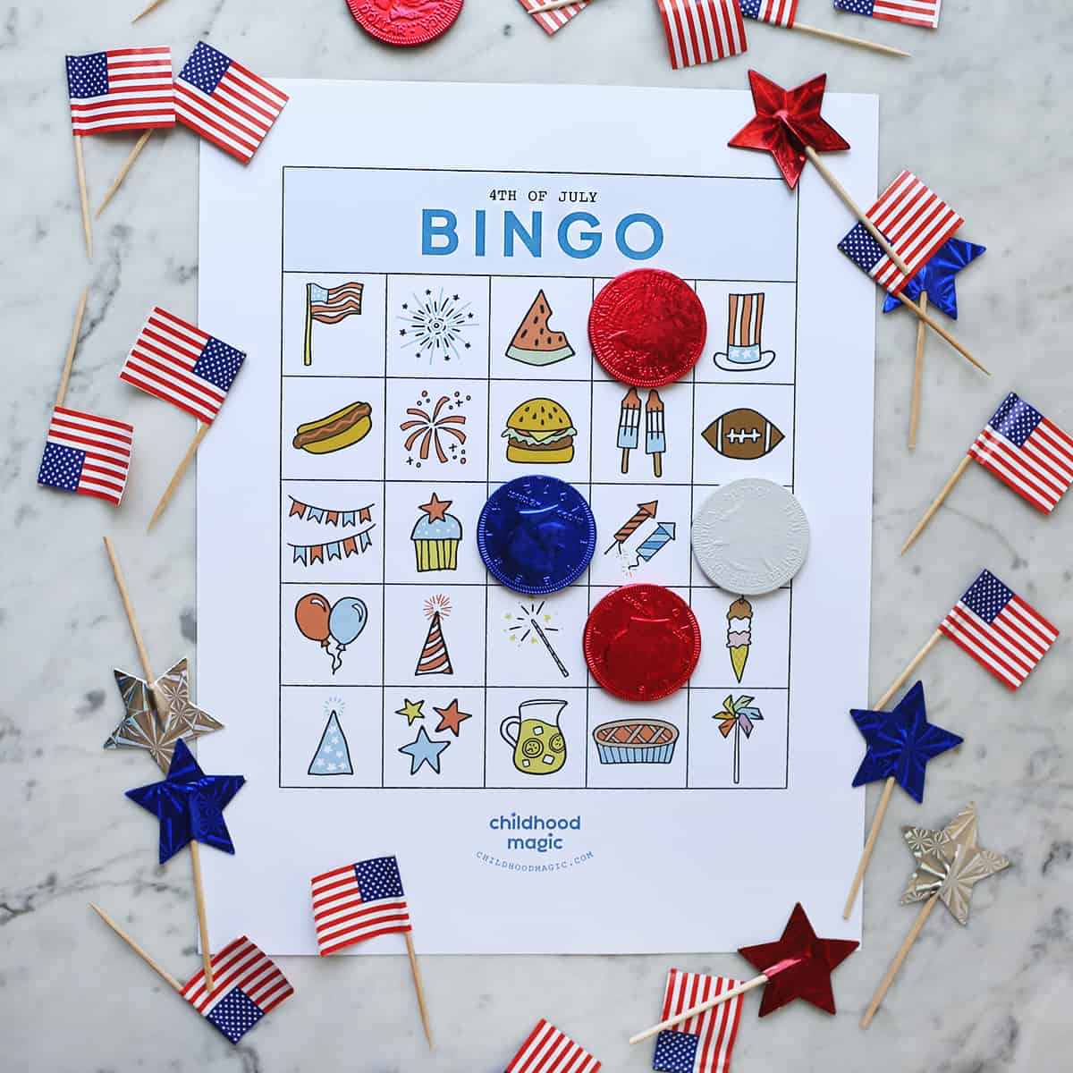 4th of July bingo cards on counter with red, white and blue coins as tokens. 