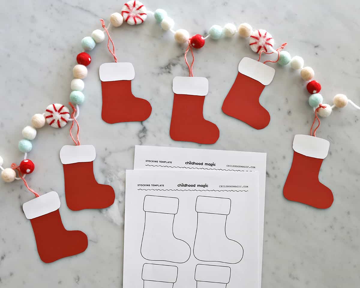 Christmas garland with cut out stockings hanging from it. 