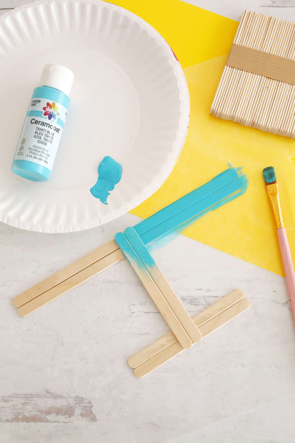 painting base of popsicle stick menorah hanukkah craft for kids