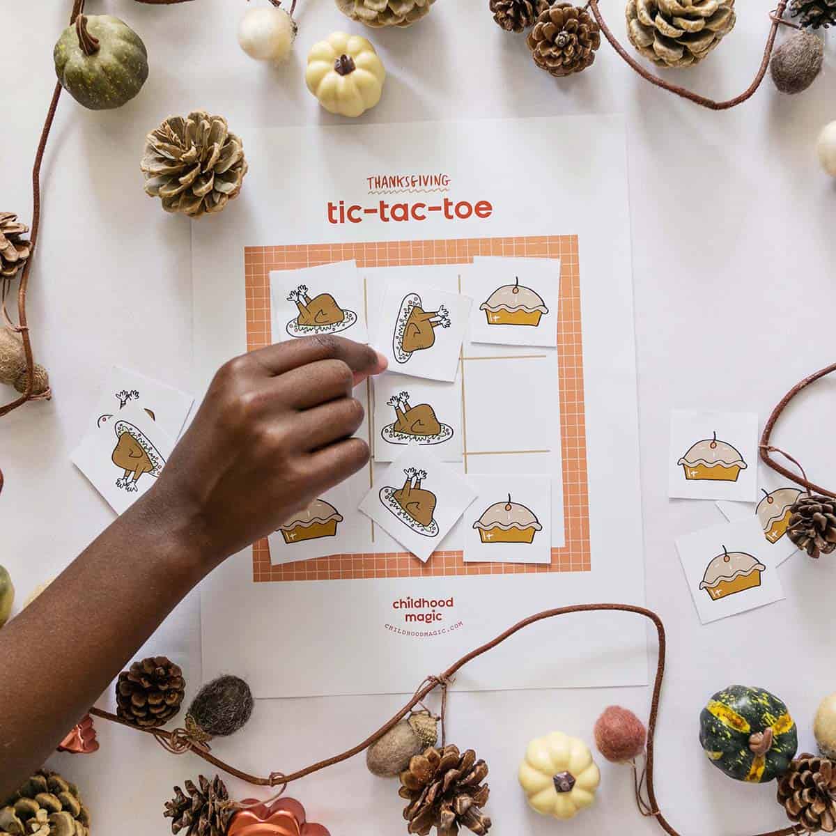 kiddo placing tic tac toe token on game board. 