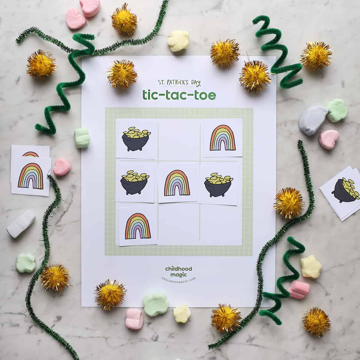 St. Patrick's Day Tic tac toe board with rainbow and pot of gold tokens. 