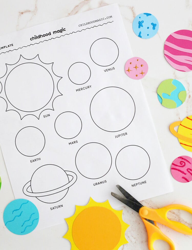 Planet-themed coloring page next to scissors and planet cut outs.