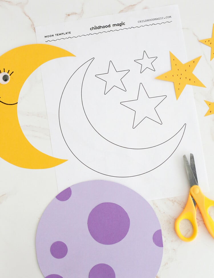 yellow and purple construction paper used to cut out moon shapes next to yellow scissors and an outline of a moon and stars.