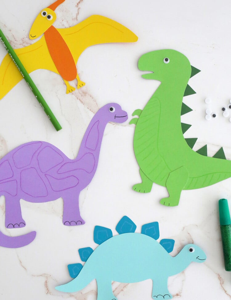 Dinosaurs cut out of colored paper and made into a kids craft.