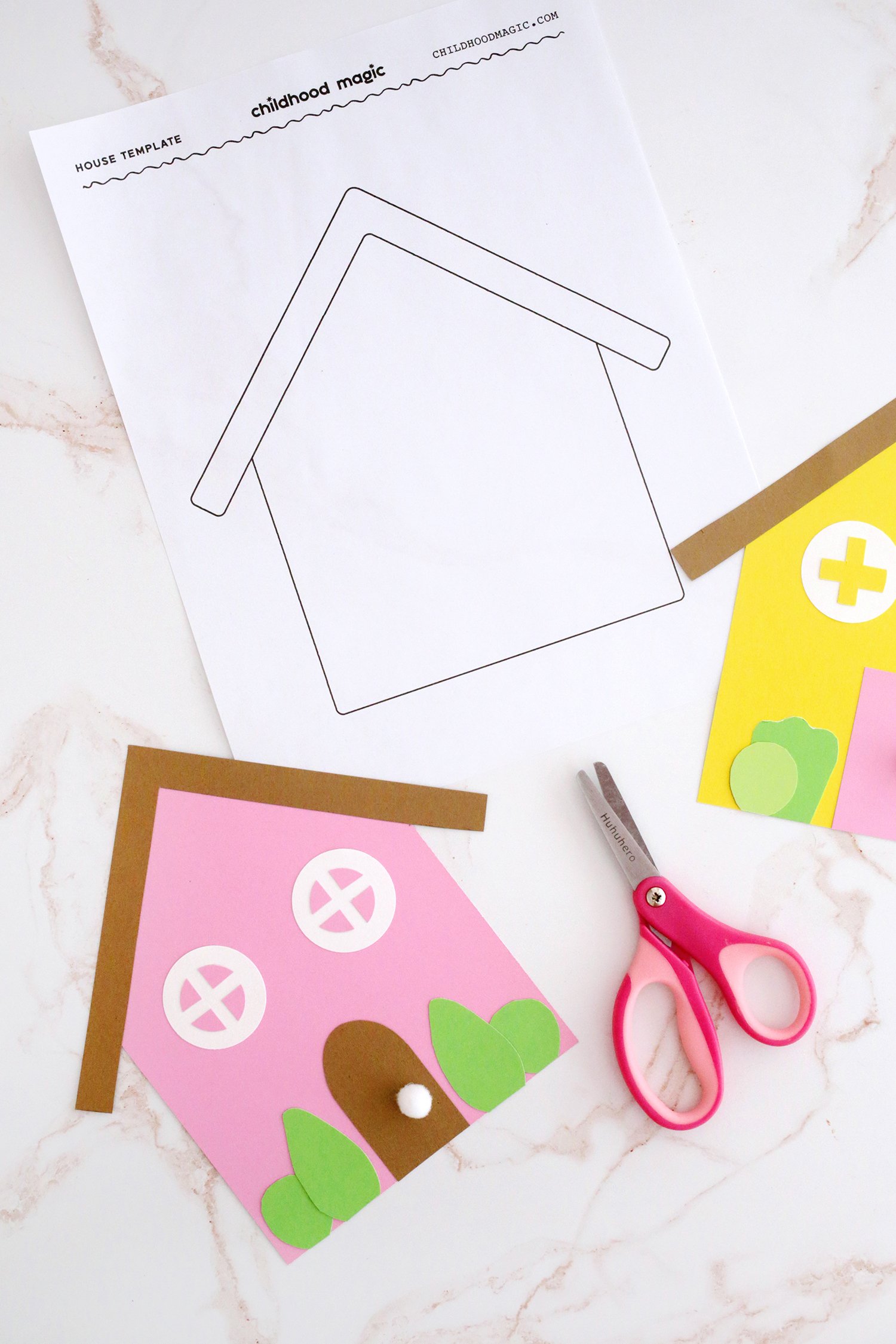 Construction paper cut out into a house shape next to a house outline on a white background. 