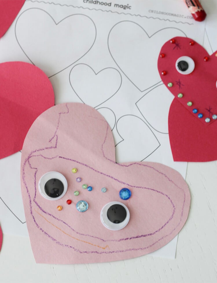 pink construction paper cut into a heart shape and decorated with stickers, googley eyes and crayons.