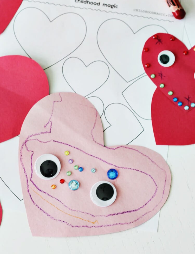 pink construction paper cut into a heart shape and decorated with stickers, googley eyes and crayons.