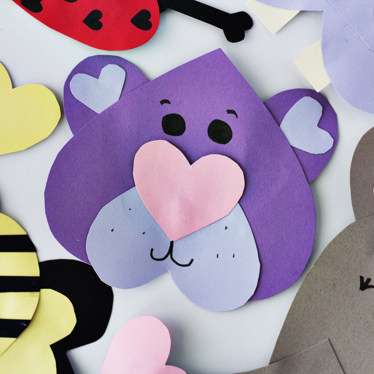 purple construction paper cut into hearts and glued together to make a bear face. 