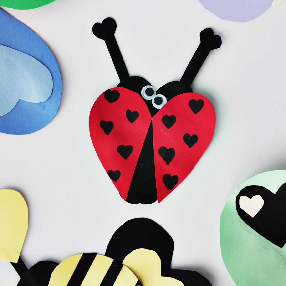 Red and black cardstock glued together in a lady bug shape with black hearts drawn on as the dots. 