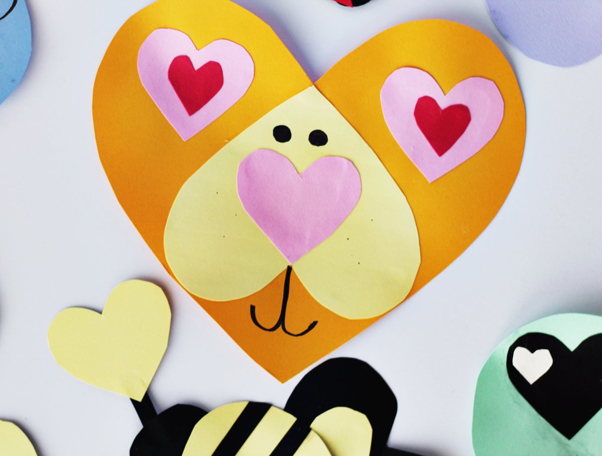 Orange and yellow cardstock paper cut into heart shapes and glued together with pink hearts to make a lion face. 