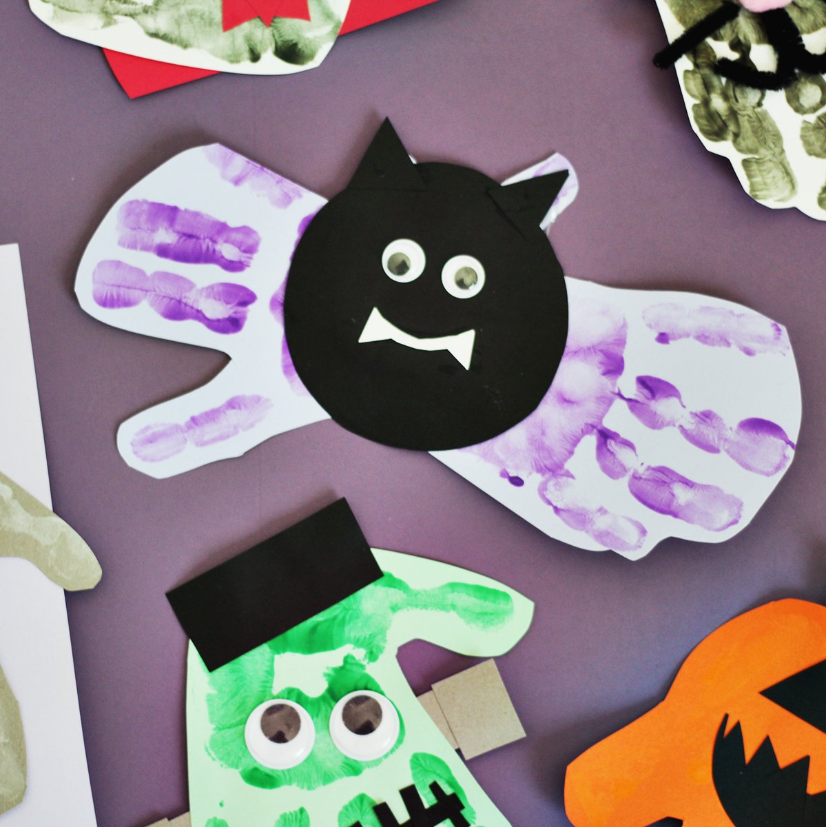 purple handprints on light purple paper glued to a black circle to make a black bat.