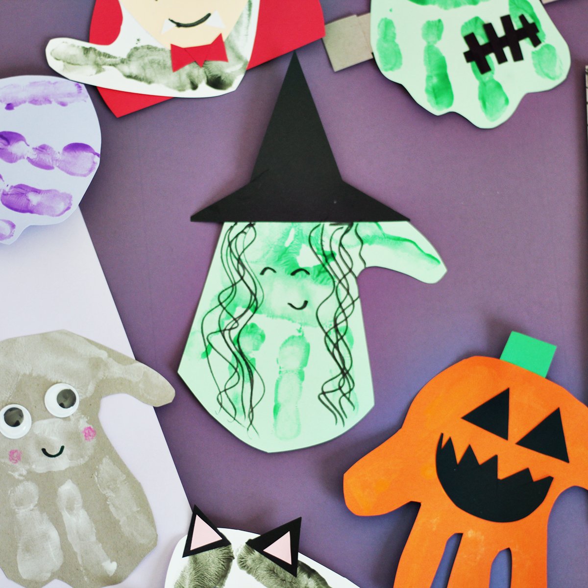 Green handprint on lighter green cardstock with a black cut out hat to make a witch handprint.