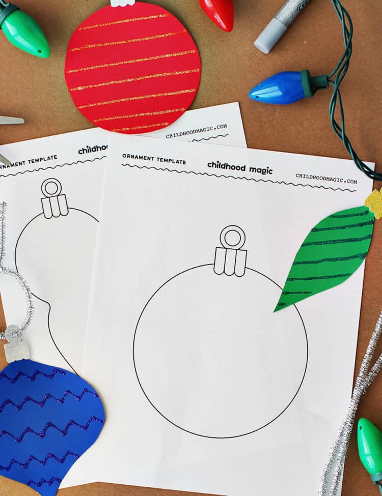 Black outline of a Christmas ornament on a white background. Ornaments cut out from cardstock and kids scissors along with silver pipe cleaners on a piece of brown craft paper.