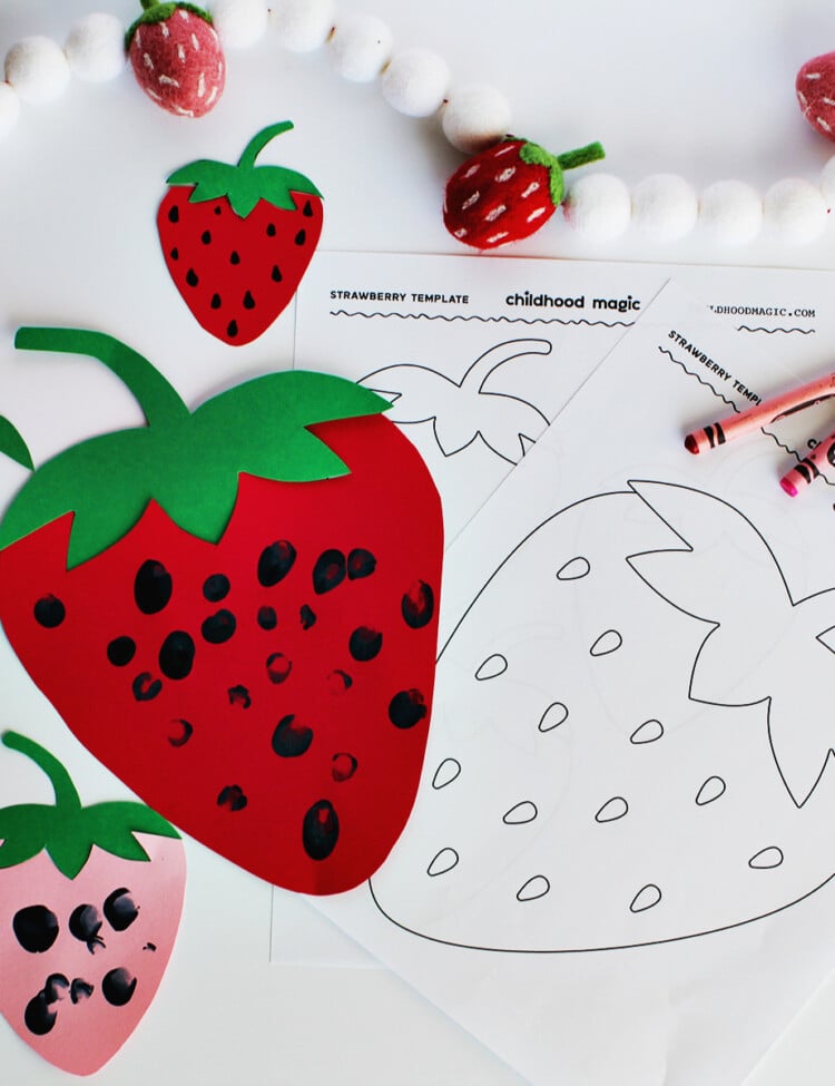 coloring sheet with a strawberry next to a cut out strawberry with black finger paint used for the seeds.