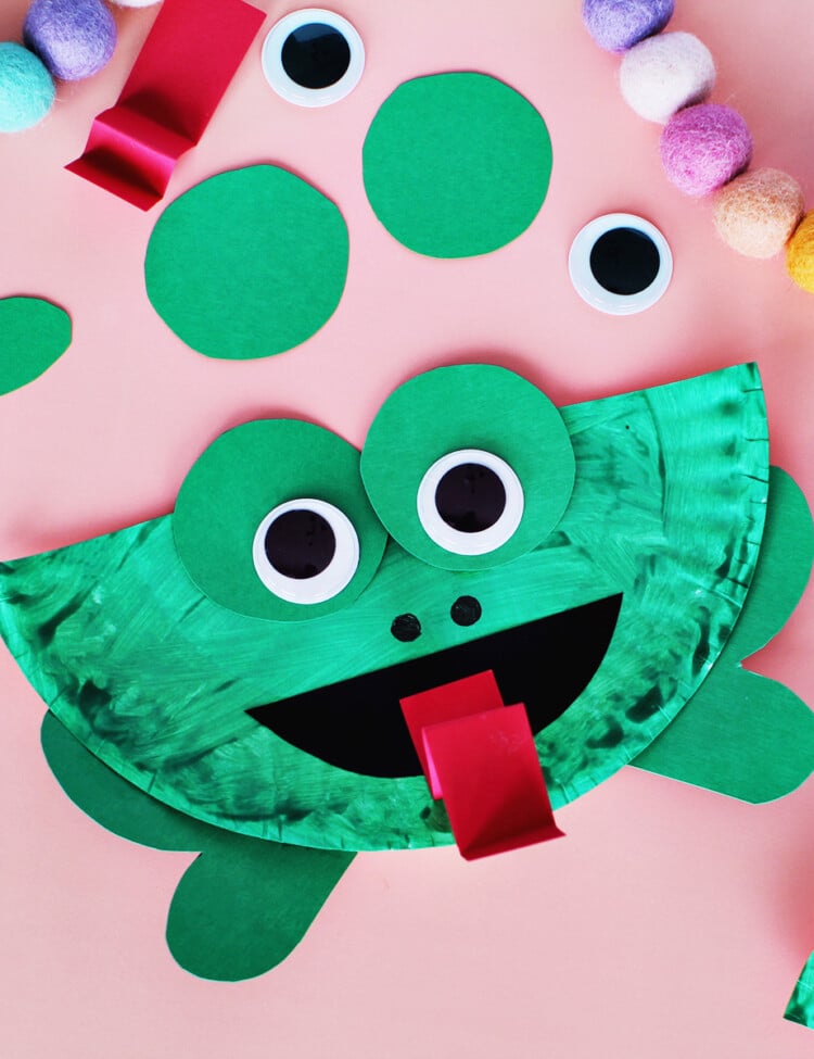 Paper plate painted green and glued with green construction paper to make a frog craft.