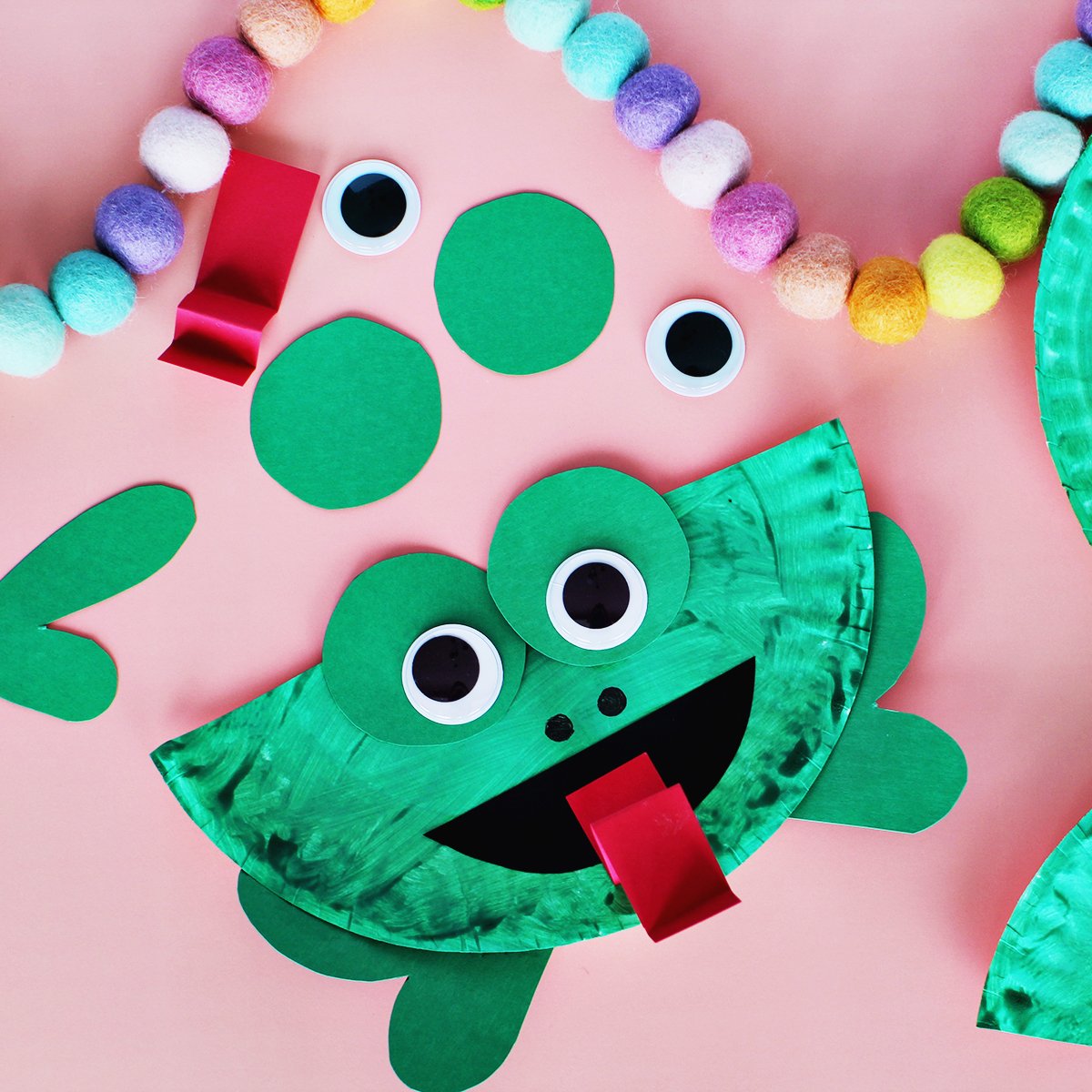 Paper plate painted green and glued with green construction paper to make a frog craft.