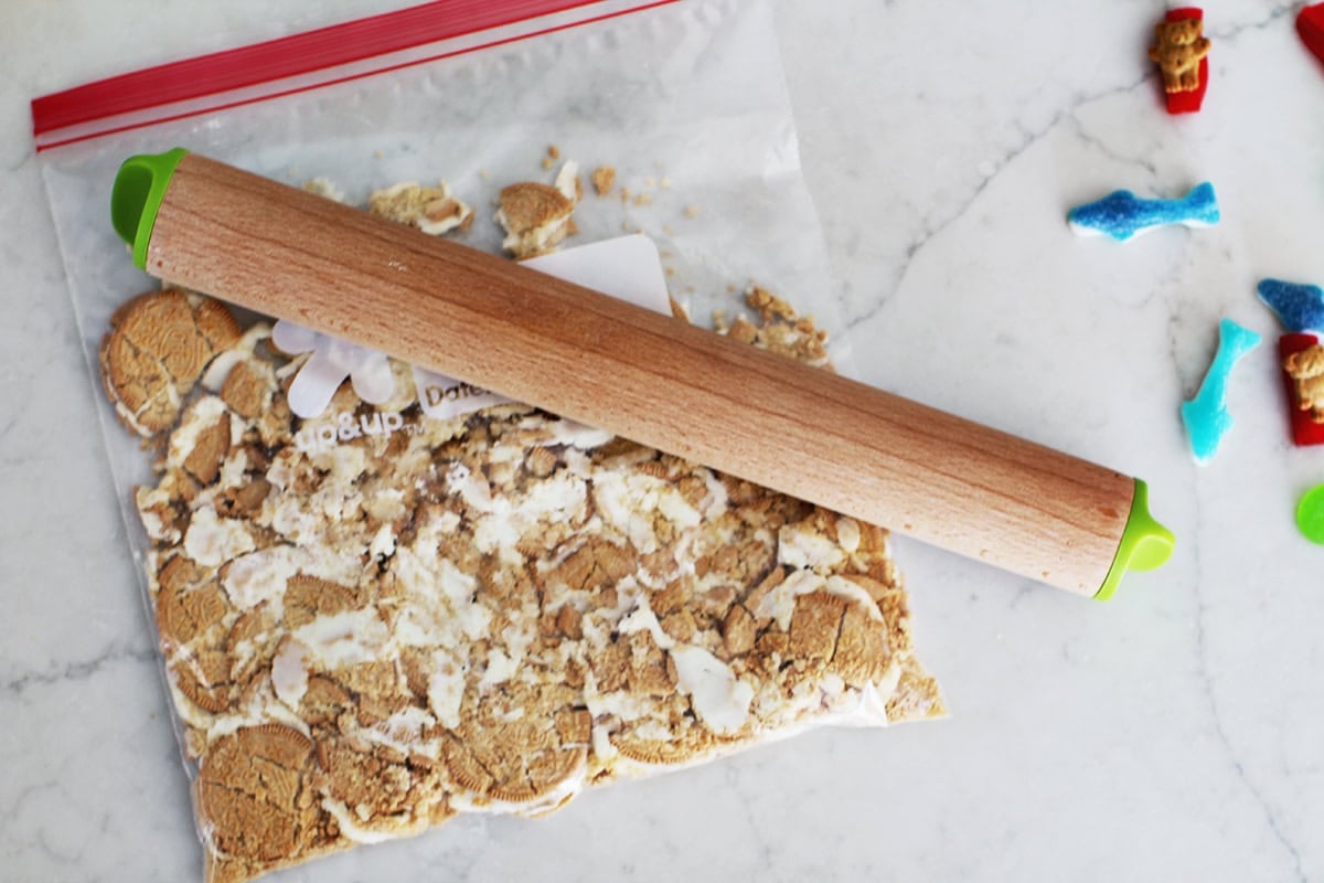 Gallon bag of golden oreos being smashed up with a rolling pin.