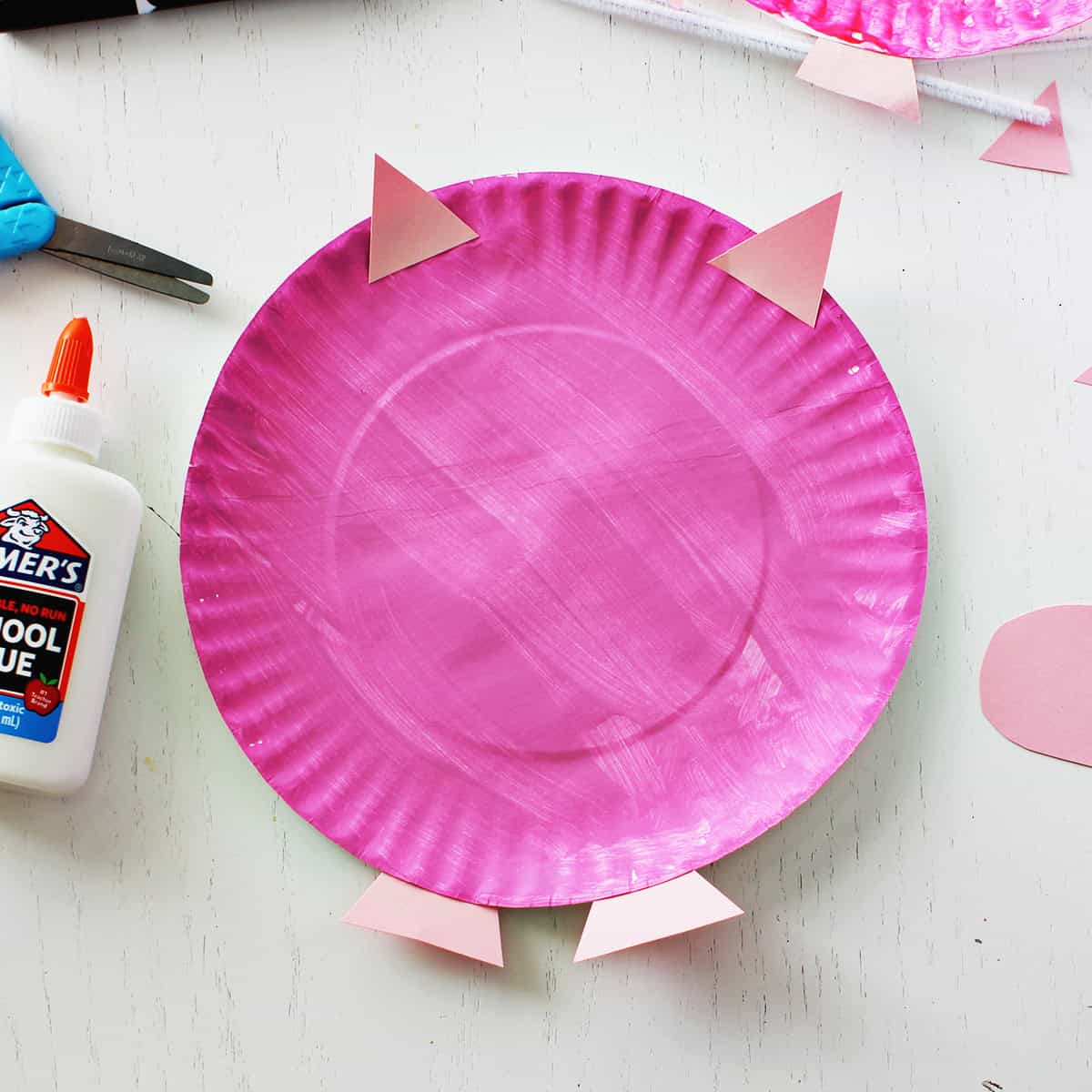 Pink paper plate painted and decorated to look like a pig.