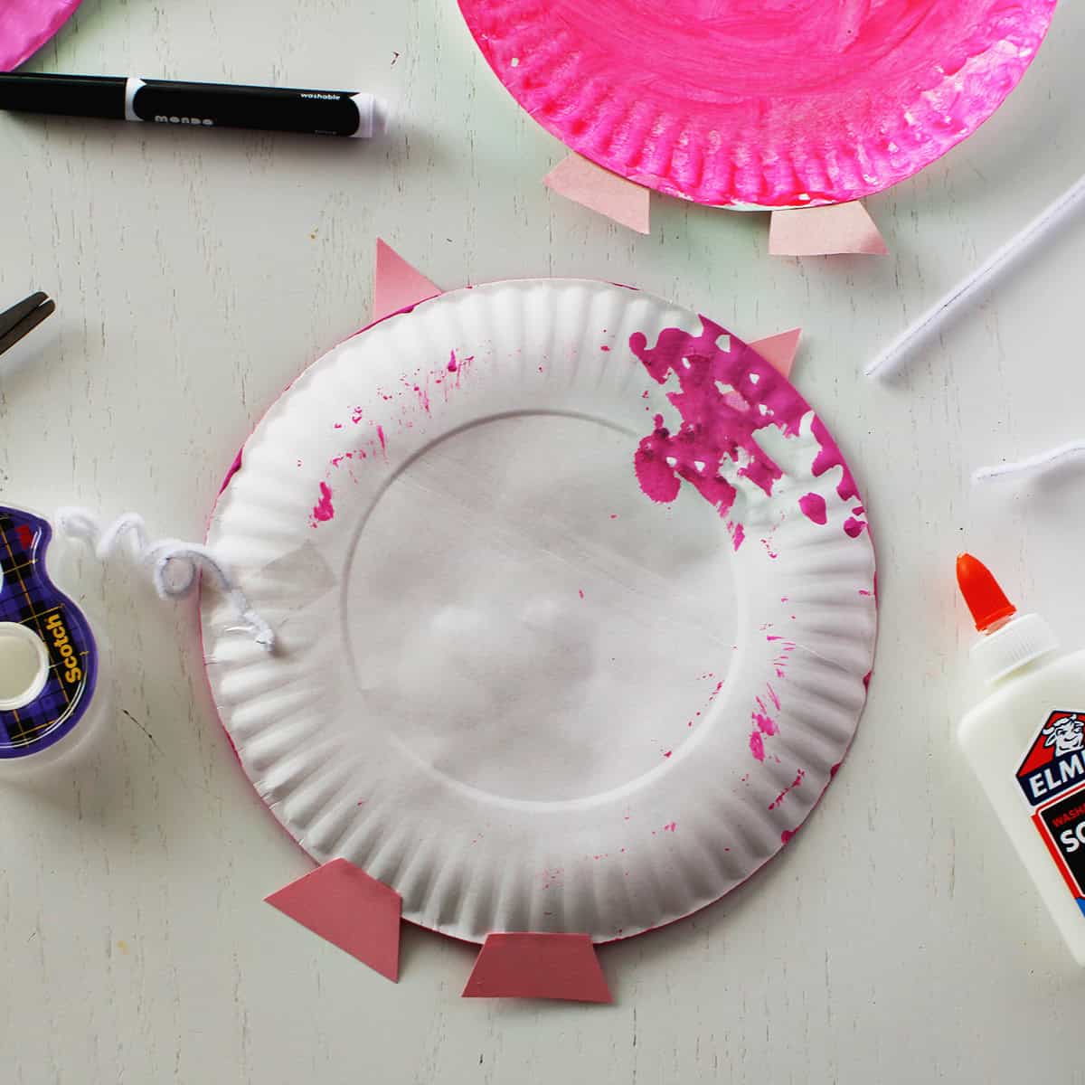 Pink paper plate painted and decorated to look like a pig.