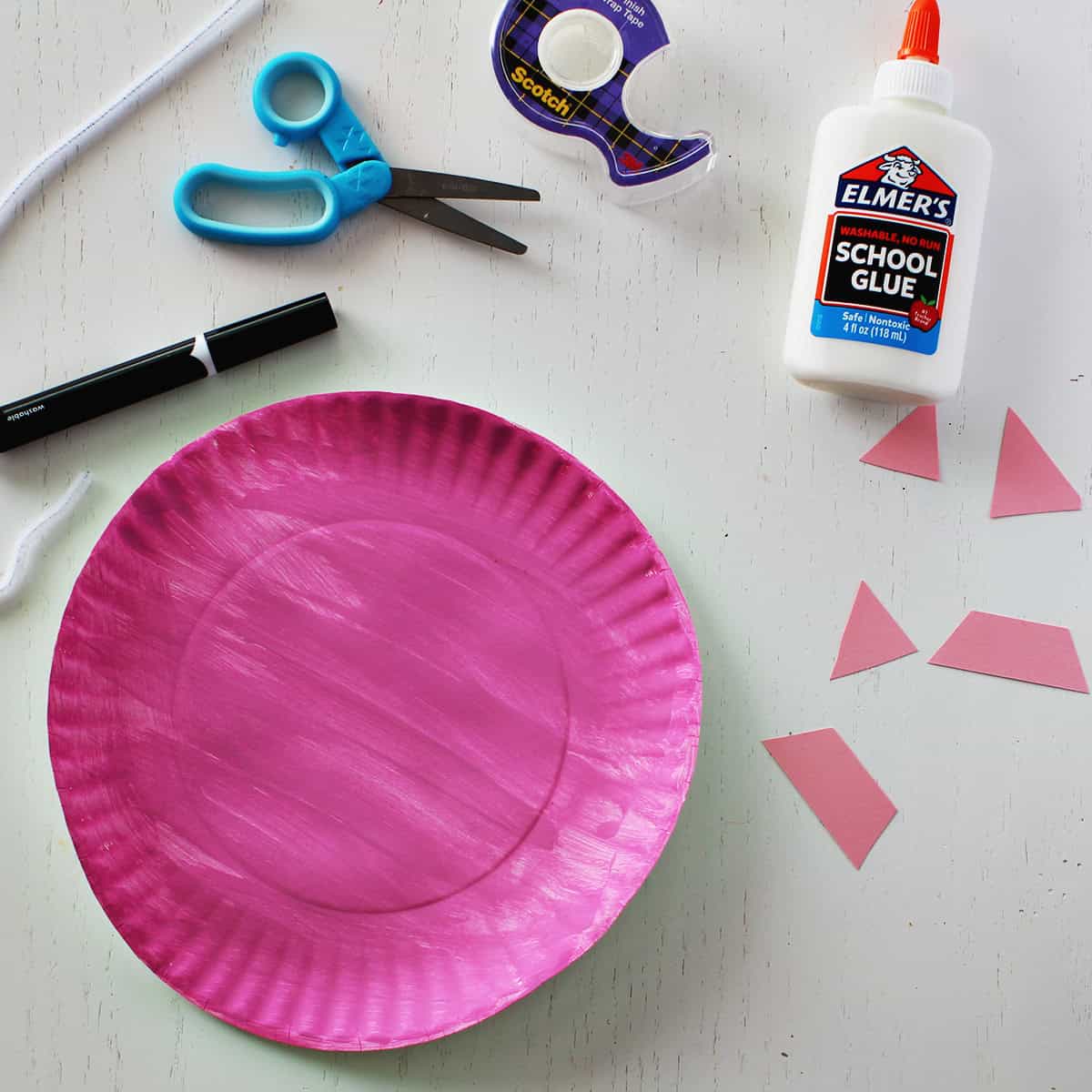 Pink paper plate painted and decorated to look like a pig.