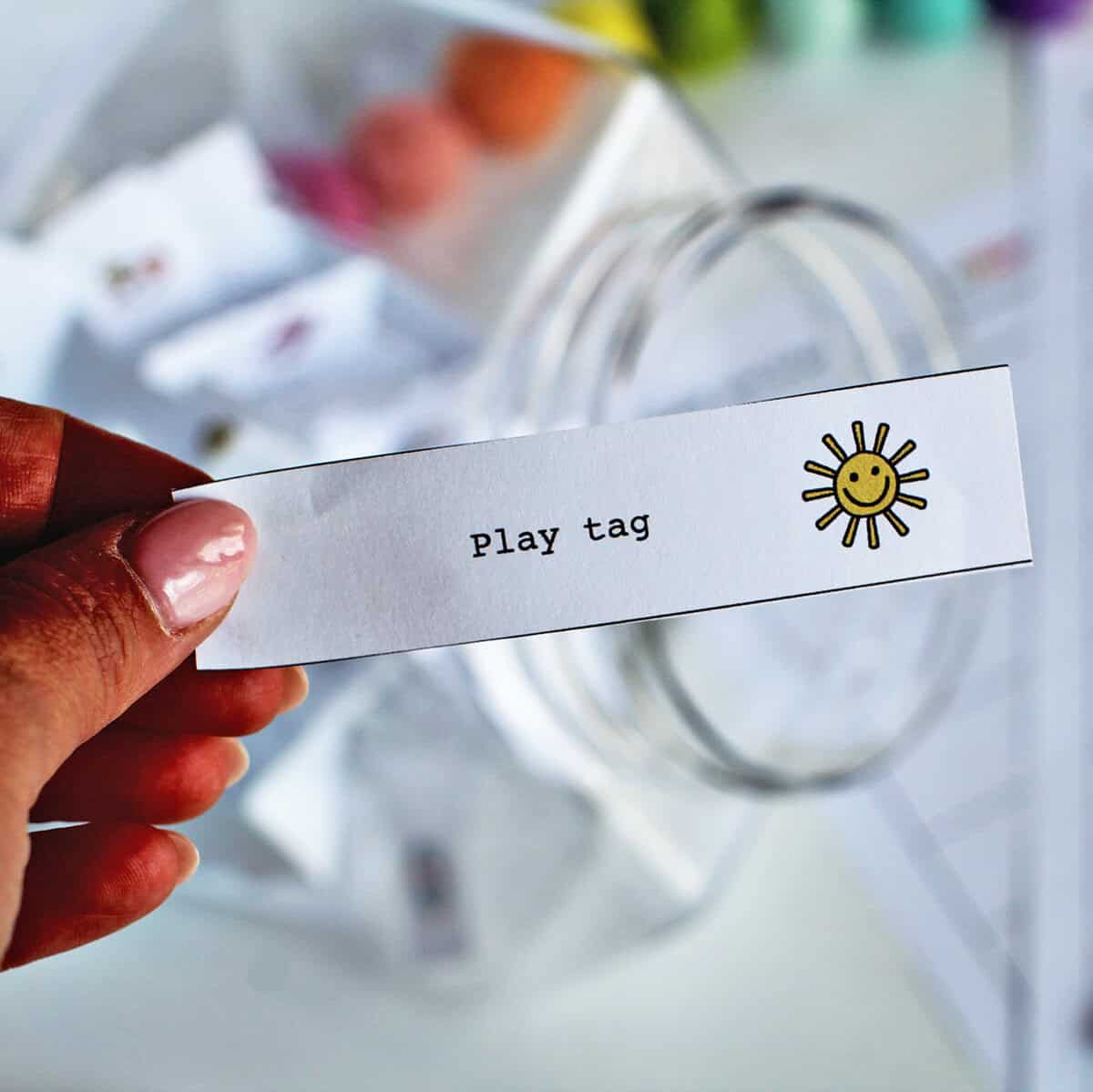 Hand holding card that reads play tag.