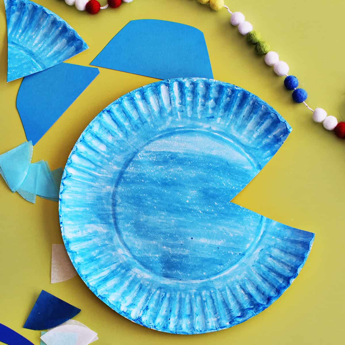 Blue paper plate with corner cut out.