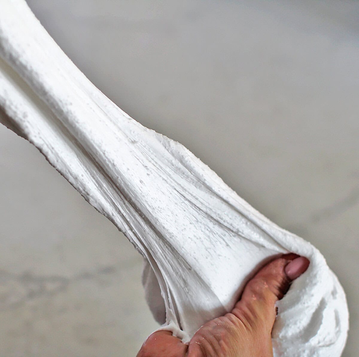 Hands stretching snow slime.