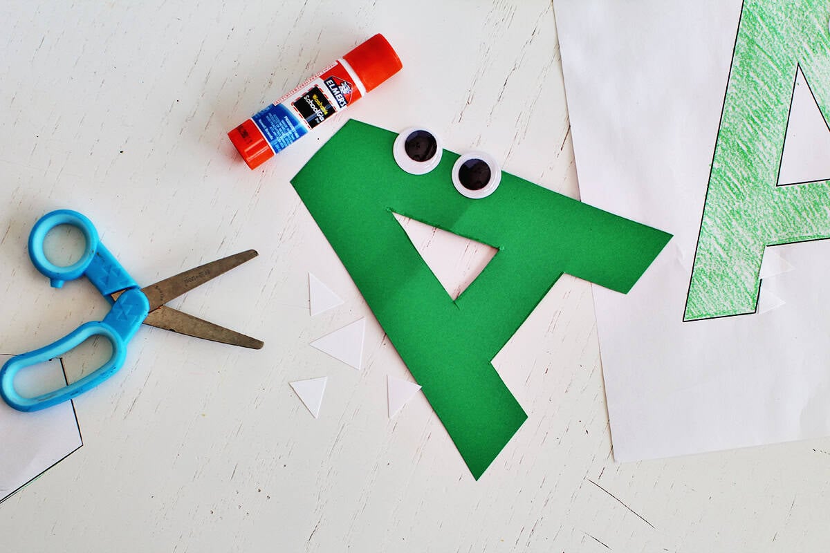 Cut out white cardstock to represent teeth on an alligator paper craft.